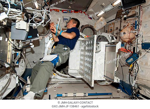 Japan Aerospace Exploration Agency astronaut Koichi Wakata, Expedition 38 flight engineer, prepares to install a Cubesat deployer