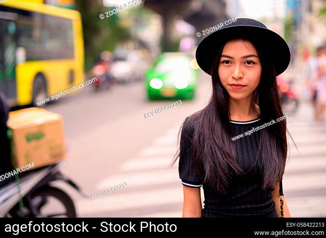 Portrait of young beautiful Asian tourist woman exploring around the city