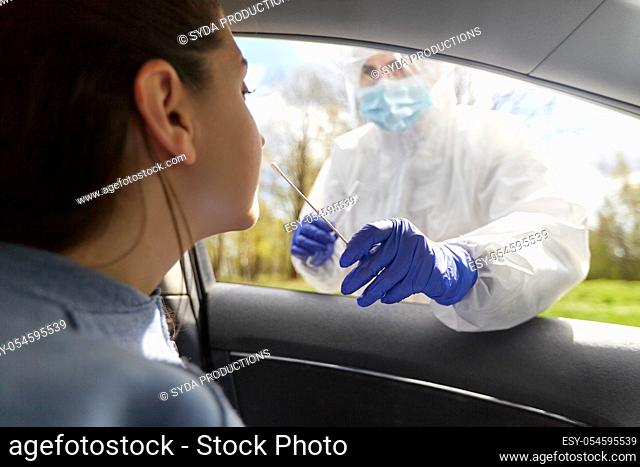 healthcare worker making coronavirus test at car
