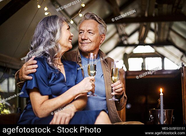 Senior couple having a candlelight dinner on a boat in boathouse