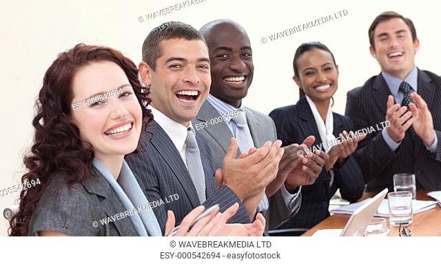 Happy businessteam laughing and clapping in a meeting