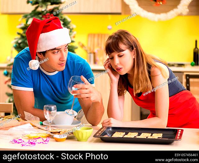 The young couple celebrating christmas in kitchen