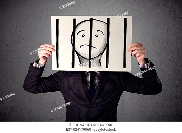 Businessman holding a paper with a prisoner behind the bars on it in front of his head