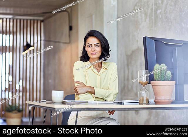 Businesswoman contemplating while sitting at desk in office