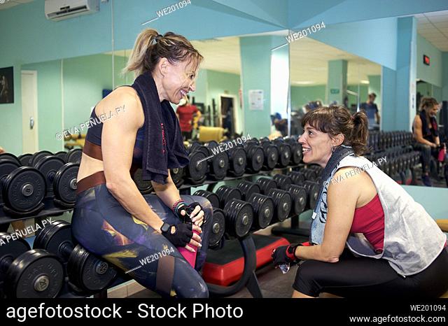 Two friends taking a break on workout together in the gym