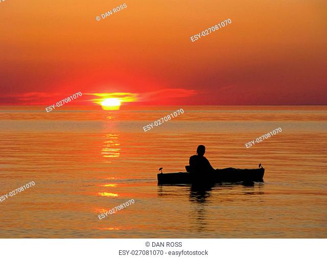 Kayaker enjoys the sunset on the still waters of Lake Superior
