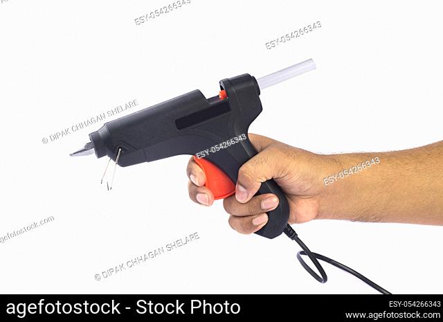 Hand holding Electric hot glue gun isolated on white background
