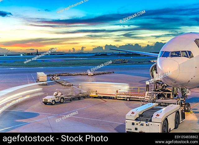 Boeing plane on the tarmac of the Okinawan airport of Naha Airport with a beautiful sunset skyline and summer clouds