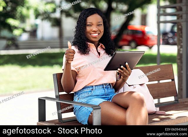 african american woman with tablet pc in city