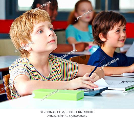 Kind im Unterricht in der Grundschule schreibt linkshändig