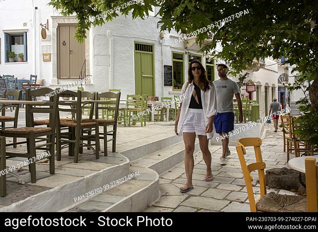 16 June 2023, Greece, Pyrgos: Tourists walk around the main square of the village of Pyrgos, the largest village on the island of Tinos in the Cyclades