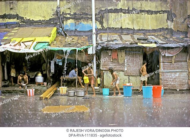 A pavement dwellers collecting rain water for their daily use Mumbai Bombay , Maharashtra , India