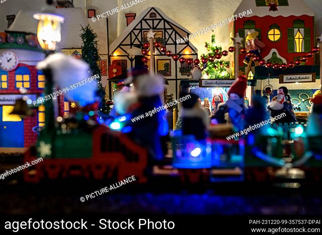 PRODUCTION - 05 December 2023, Bavaria, Coburg: A model train runs past the stalls of a miniature Christmas market. Around 20 meters as the crow flies from the...