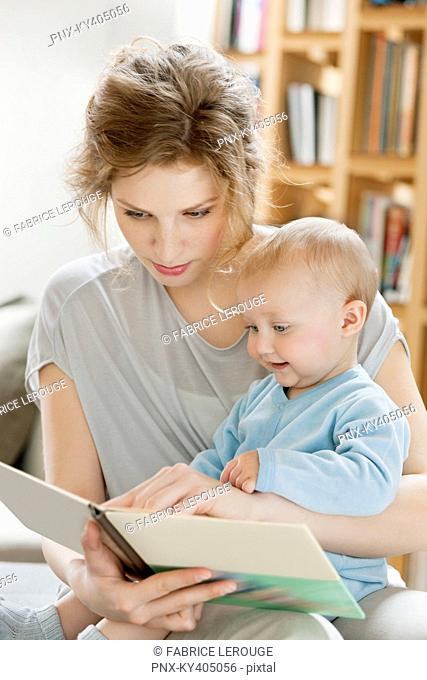 Woman teaching her daughter from a picture book