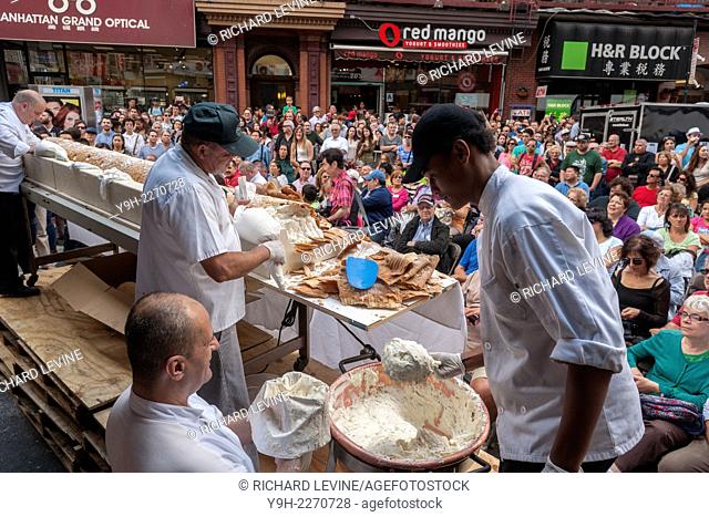 Workers from Ferrara Bakery and Cafe put the finishing touches on their attempt to assemble the world's largest cannolo singular of cannoli at the 88th Annual...