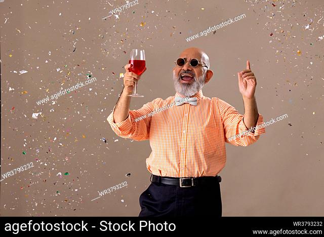 Senior man celebrating party with a glass of red wine