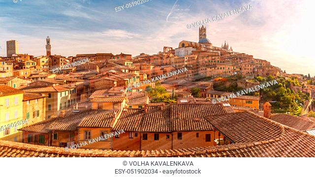 Beautiful panoramic view of Old Town with Dome and campanile of Siena Cathedral, Duomo di Siena, and Mangia Tower or Torre del Mangia at sunset, Siena, Tuscany