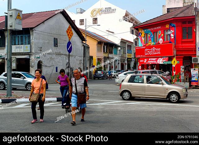 Georgetown, Penang, Malaysia - April 18, 2016 : few local people and cars walking driving around the street