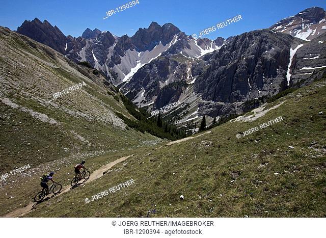 Mountain bike riders on the trail between the Kreuzjoch mountain gorge to the Ju dles Cacagnares, Parco naturale Fanes-Sennes-Braies, Veneto, South Tyrol, Italy