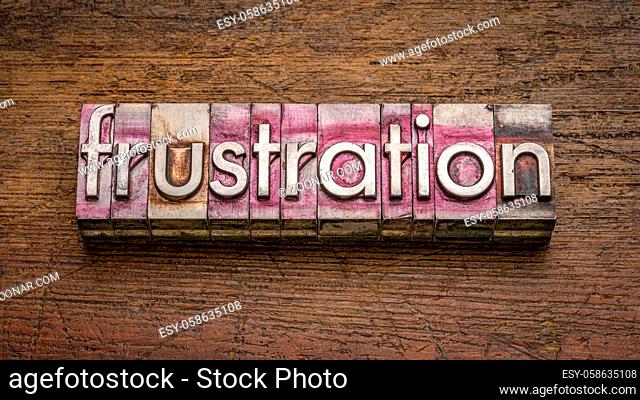frustration word abstract in gritty vintage letterpress metal type stained by printing ink against rustic wood, negative emotion