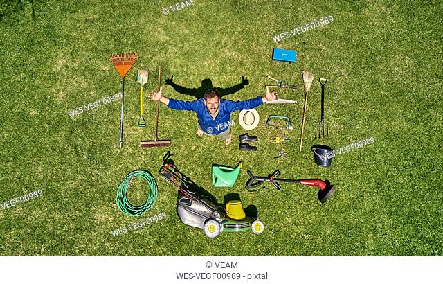 View from above of a gardener in standing on meadow with all the tools he need for take care of garden