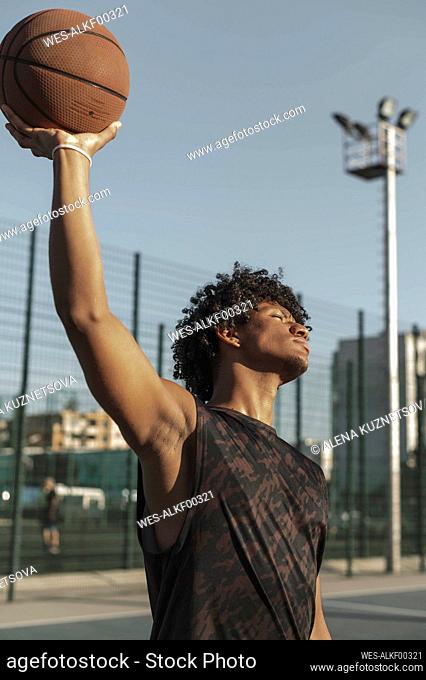Athlete holding basketball in hand at sports court