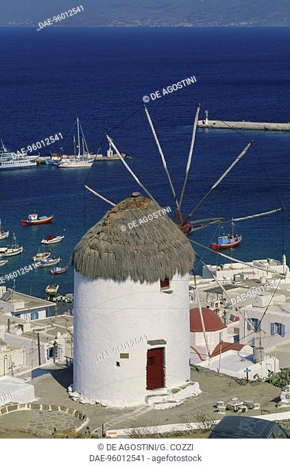 Windmill in Kato Mili, with the port of Mykonos town in the background, Mykonos, Cyclades islands, Greece
