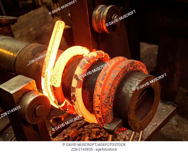 Red hot metal being made into a spring