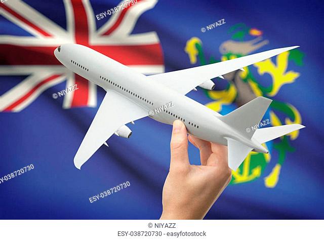 Airplane in hand with national flag on background - Pitcairn Islands
