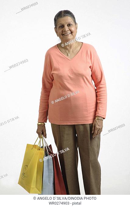 Old lady holding colourful shopping bags in her right hand MR 703A