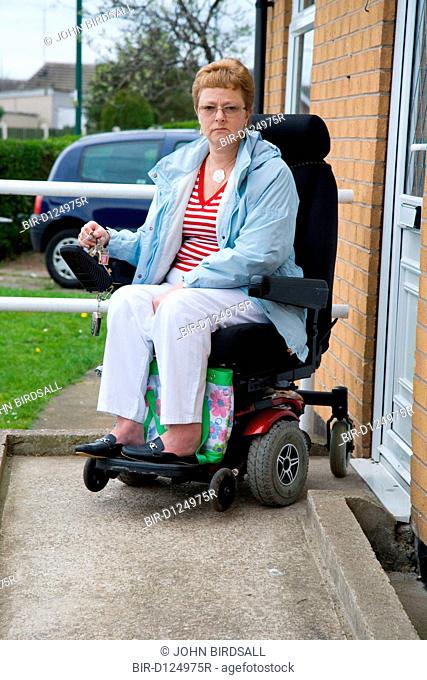 Older woman wheelchair user leaving her house to go out