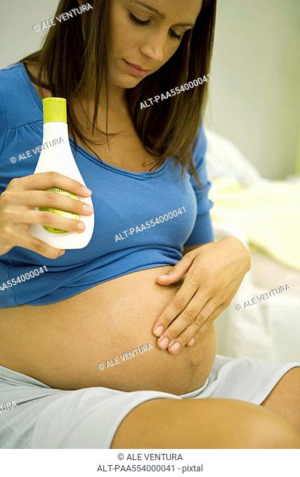 Pregnant woman moisturizing stomach