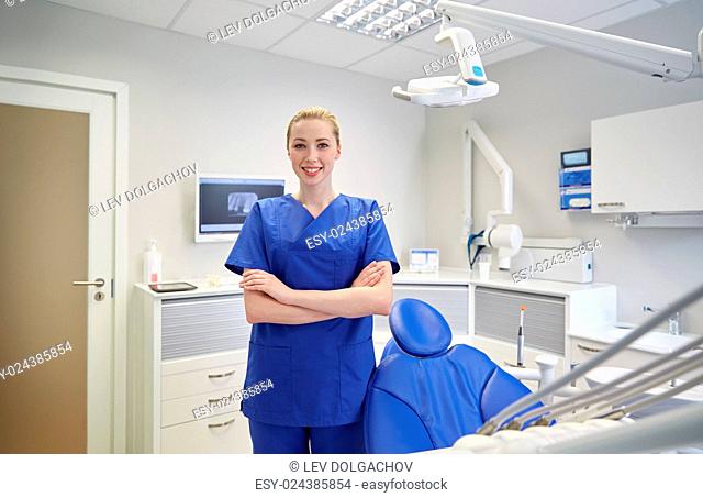 people, medicine, stomatology and healthcare concept - happy young female dentist at dental clinic office