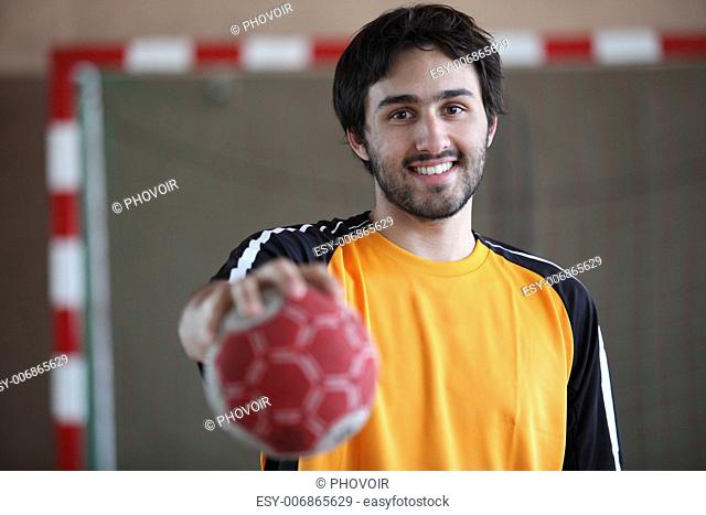 portrait of young handball player holding out ball