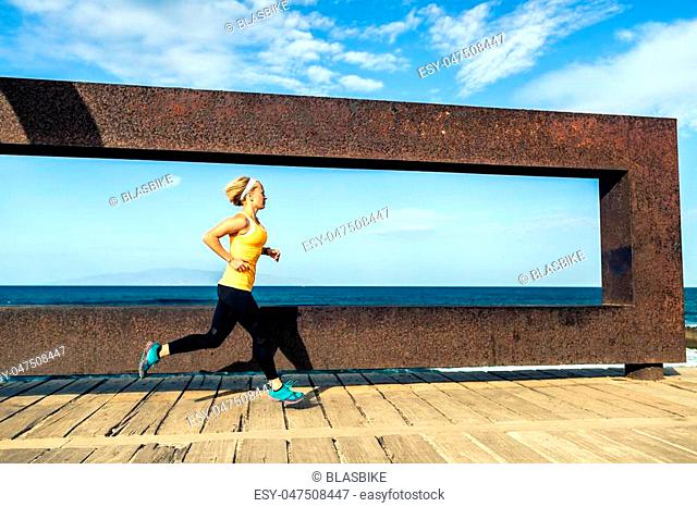 Young woman running in mountains on sunny summer day. Female runner exercising outdoors in nature, sunset