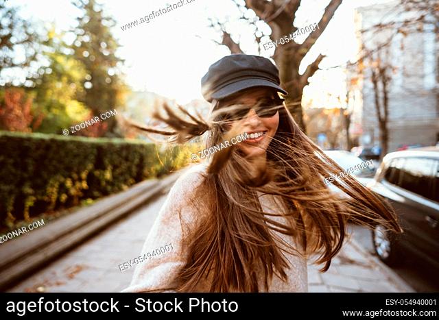 Street portrait of young beautiful fashionable woman wearing stylish clothes walking at the old city