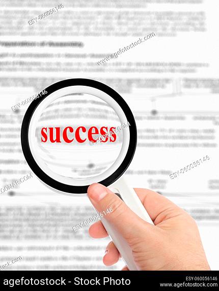 Magnifying glass in hand and word Success - business background