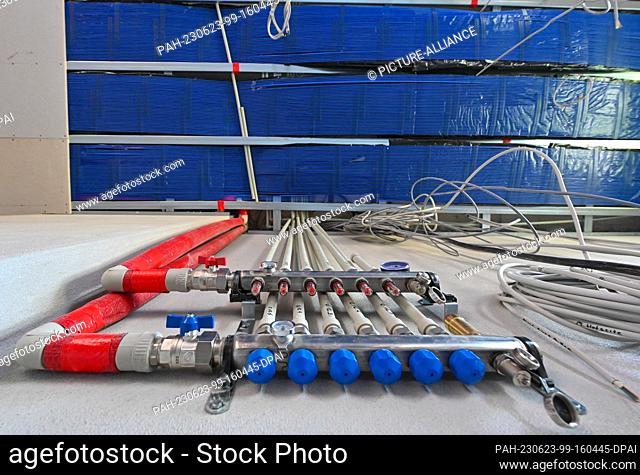 PRODUCTION - 22 June 2023, Brandenburg, Petersdorf: On a construction site in one room of a house, capillary tube mats are installed on the ceiling as surface...