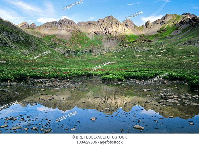 A tarn just below Clear Lake catches the reflections of a jagged mountain ridge high in the San Juans, Colorado, USA