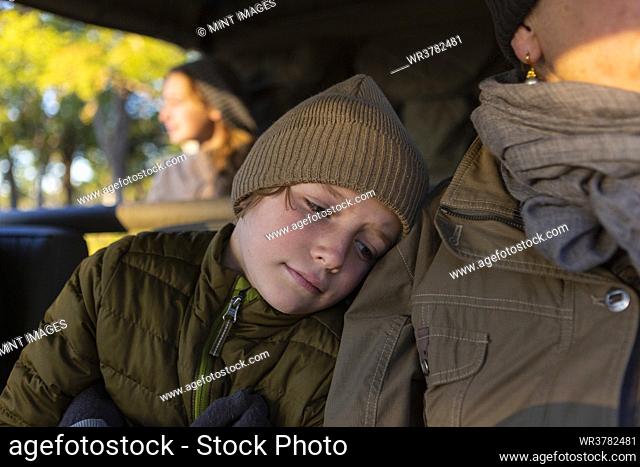 Close up of a boy and his mother in a safari jeep in early morning sun