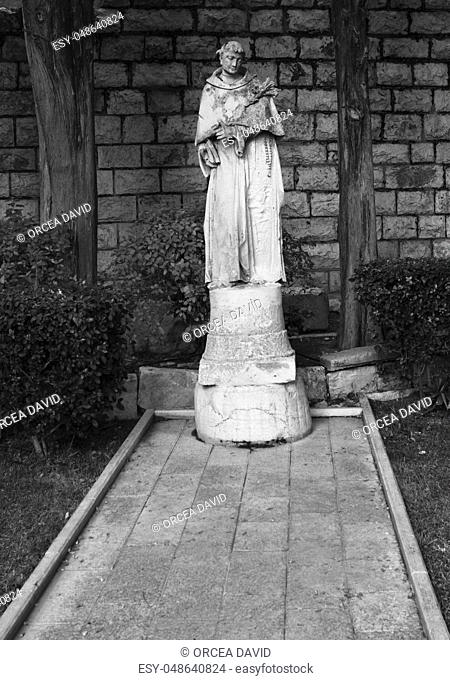 holy man statue in a church garden black an white