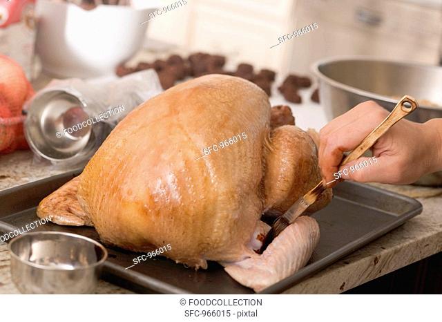 Brushing turkey with marinade