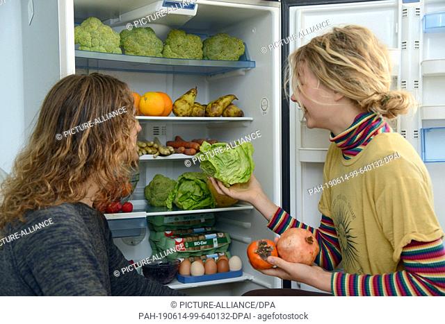 13 June 2019, Rhineland-Palatinate, Trier: Lenny (l) and Freja take fruit from their fridge, which they have ""fished"" from the waste bins of a supermarket