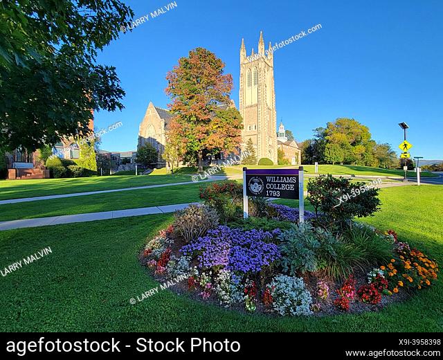 View of a flower bed with a Williams College sign in front of the Thompson Memorial Chapel in Williamstown, MA during fall