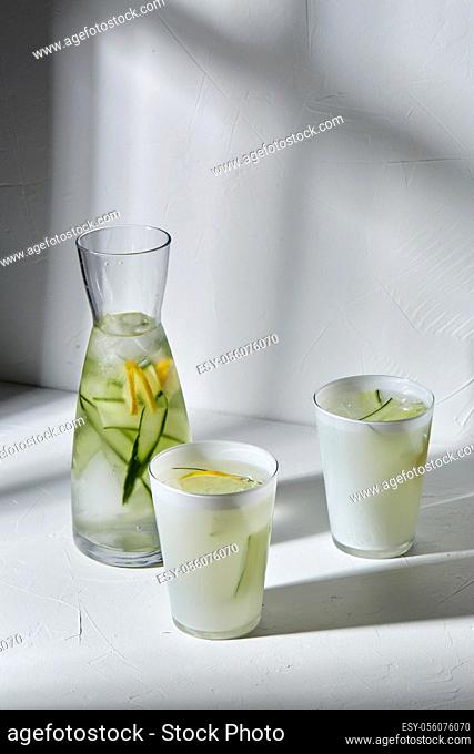 glasses with lemon water and cucumber on table