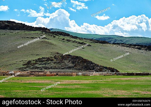 Mongolian traditional cemetery near Tsagaannuur settlement under blue sky and clouds
