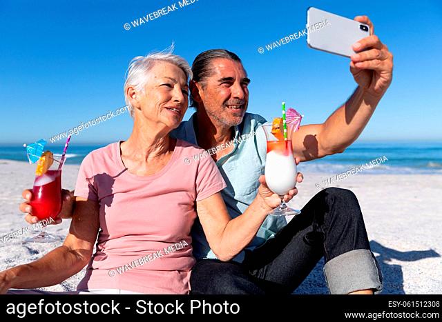 Senior Caucasian couple taking a selfie at the beach
