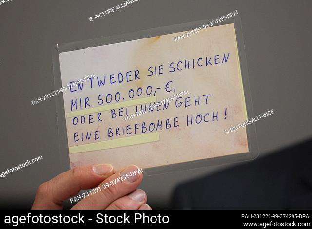 21 December 2023, Bavaria, Kempten: Josef Ischwang, head of the Kempten criminal investigation department, holds a postcard from a blackmailer at a press...