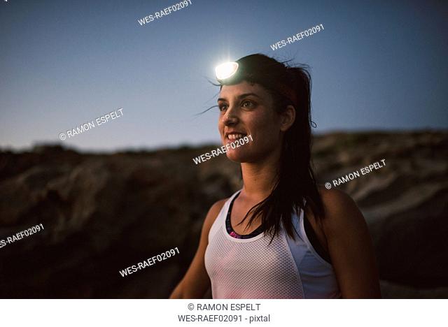 Sportive woman with headlamp in the evening