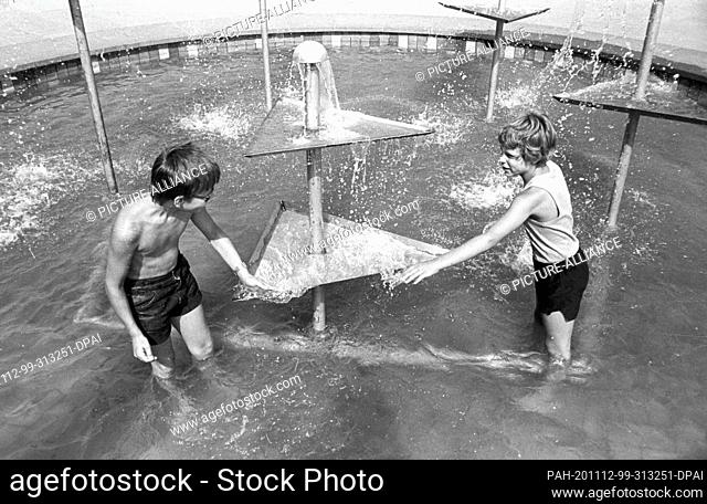 30 August 1984, Saxony, Eilenburg: Children refresh themselves in the summer of 1984 in the market fountain of Eilenburg